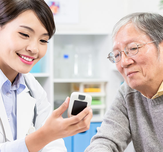 Pharmacist talking to diabetes patient looking at blood sugar monitor